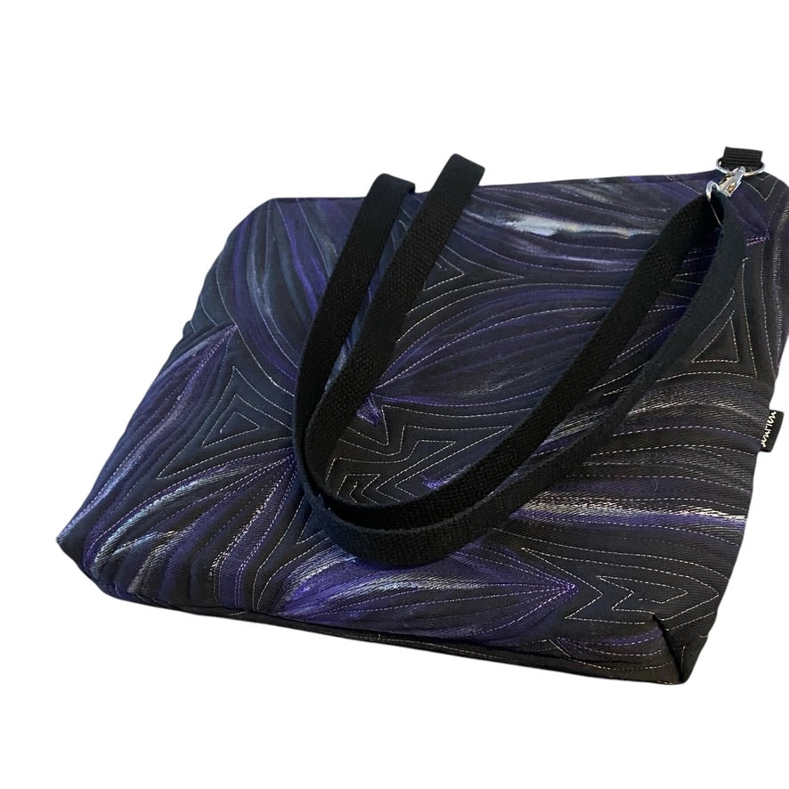 A unique art bag with a hand-painted leaf pattern and free motion quilting